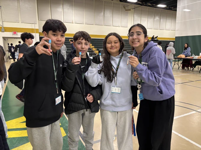 Students holding up fake blood vial samples