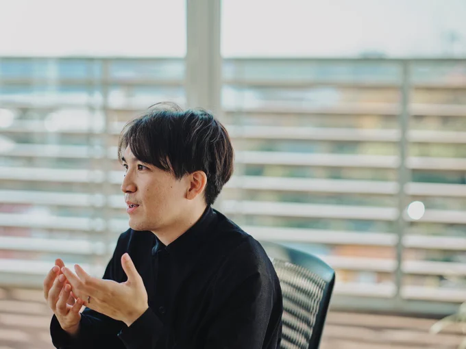 写真：テーブルに向かい、手振りを交えながら話すフラーの取締役CDO 櫻井さん。