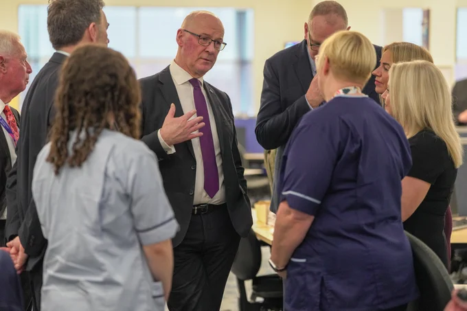 First Minister John Swinney with NHS 24 and Scottish Ambulance Service staff at Caledonia House, Glasgow.