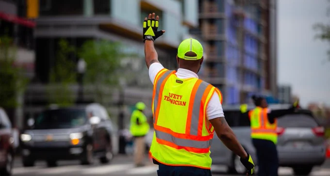 A safety technician directs traffic. (Image credit: DDOT)