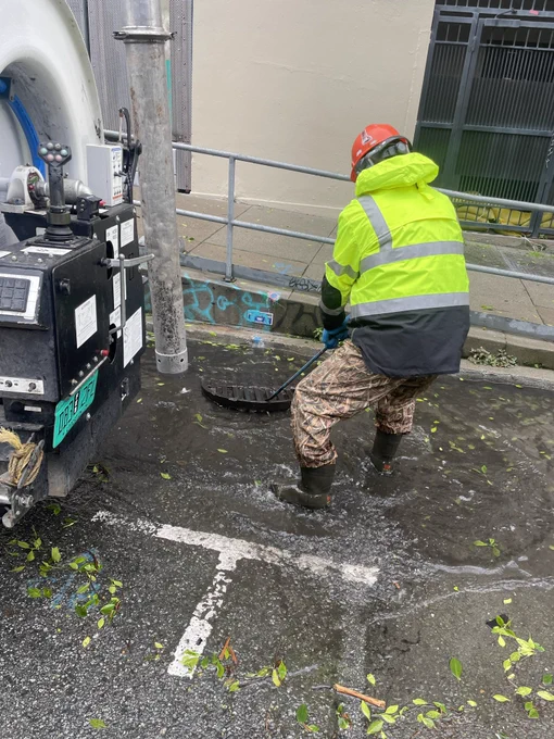 SFPUC crew member clearing out a clogged storm drain.