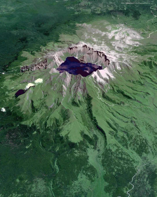Satellite image showing a large volcanic caldera with a deep lake at its center amid lush vegetation.