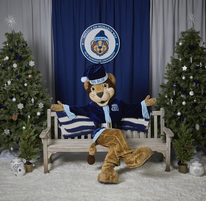 Big Blue in a santa suit with arms outstretched