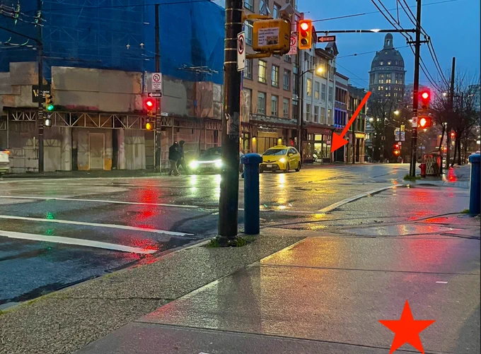 Street scene. Corner at intersection on one side has star. On other side a little way down the block arrow points to a storefront.