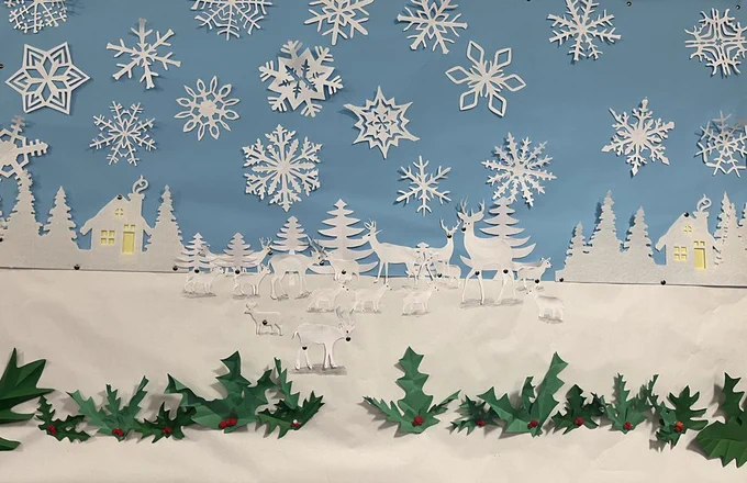 Paper collage snow scene frieze with fir trees, reindeer, and holly from Burnt Oak children's library