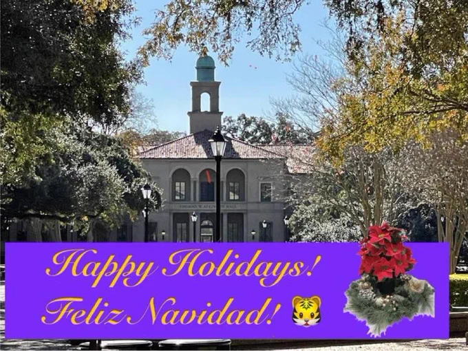 Outside, surrounded by trees and with a neoclassical building in the background, a message says Happy Holidays! Feliz Navidad!