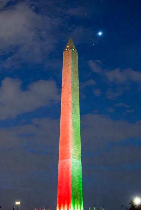 The Washington Monument lit up in red and green.