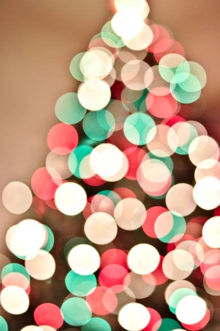 Festive abstract bokeh image of Christmas lights creating a blurred colorful pattern.
