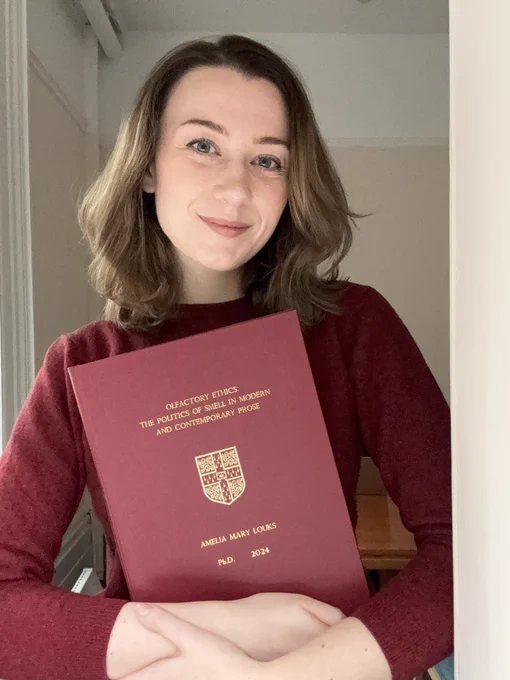 Dr Ally Louks photo with her PhD thesis titled, "Olfactory Ethics: The Politics of Smell in Modern and Contemporary Literature."