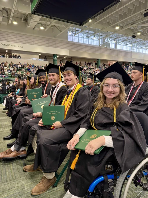SUNY Oswego graduates pose at their December commencement ceremony in Marano Campus Center with their diplomas.