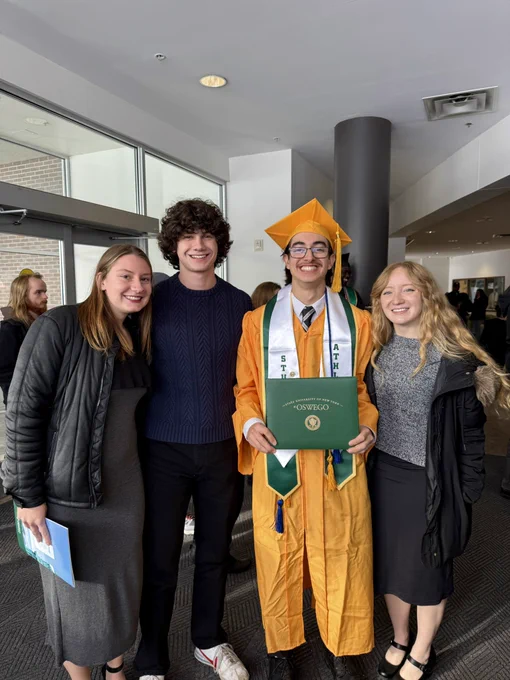 A SUNY Oswego student with their diploma and family in Marano Campus Center after commencement.