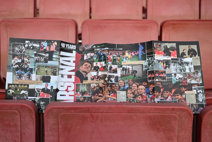 The rollfold cover of the matchday programme, celebrating 40 Years of Arsenal In Community, displayed in the seats at Emirates Stadium 