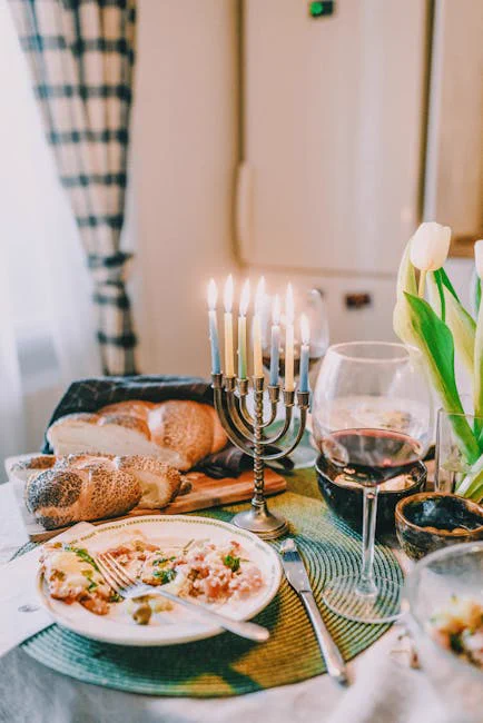 A cozy and festive Hanukkah dinner setting featuring a menorah, challah bread, and traditional Jewish cuisine.