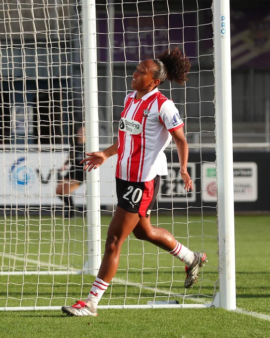 Atlanta Primus celebrates scoring against Royston Town, wearing the red and white home kit