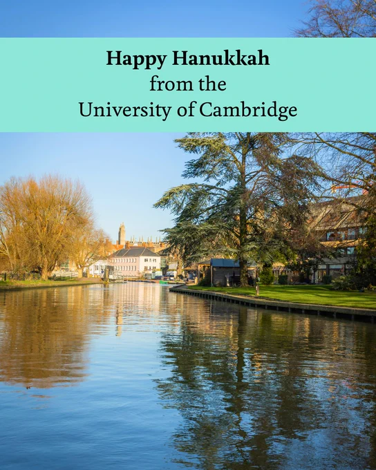 A serene view of the River Cam with lush green trees and clear blue skies. A text overlay reads: "Happy Hanukkah from the University of Cambridge".