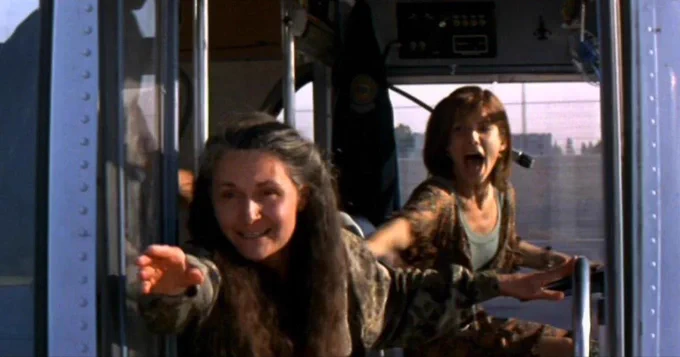 A frame from the movie Speed where Beth Grant reaches out of the bus, knowing it’ll probably blow her up.