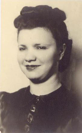 Vintage black and white portrait of a smiling woman with a stylish hairdo, wearing a buttoned outfit.