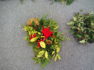 Festive wreath decorated with foliage, pine cones and red flowers