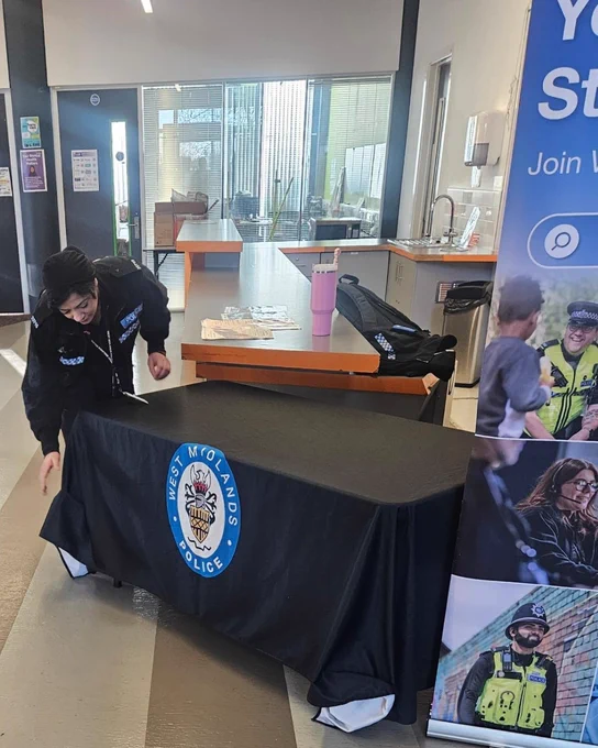 PC Begum setting up the table and putting on a table cloth