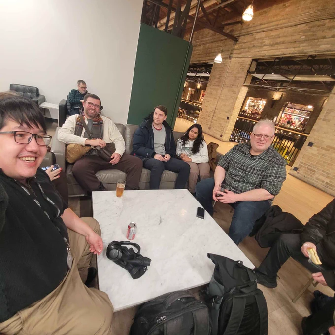 A group of smiling Winnipeggers around a table during the latest Urbanist Hangout at the Forks.