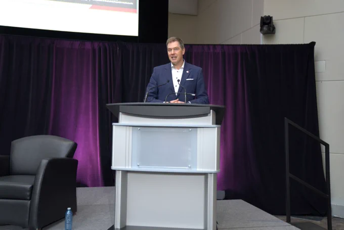 Jeremy de Beer speaking on stage.