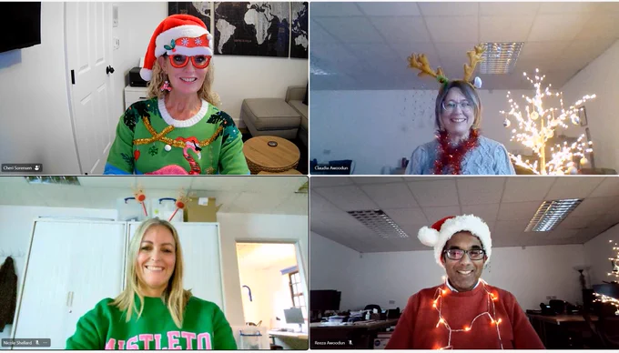 four office workers all wearing christmas jumpers and accessories for Christmas Jumper Day for Save the Children.