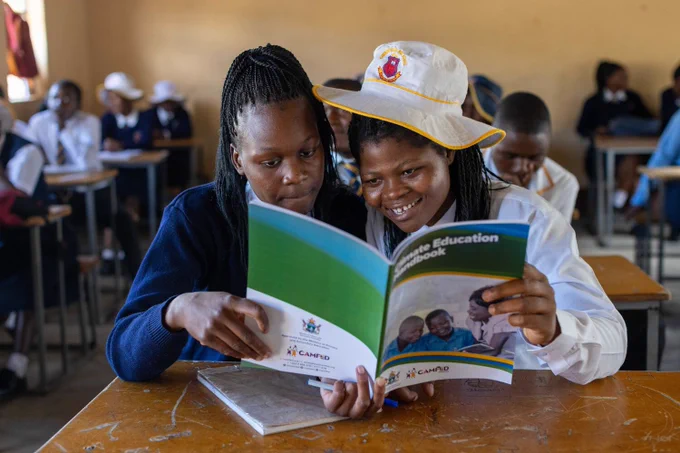 Secondary students with CAMFED's new Climate Education Handbook at a school in Wedza, Zimbabwe.