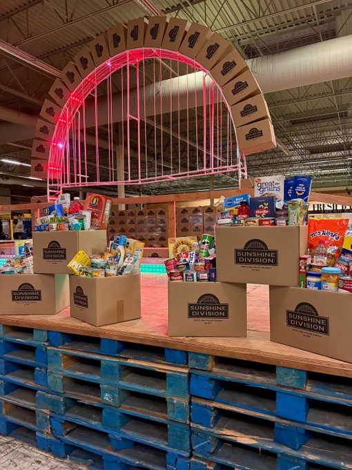 A sunshine arch made of boxes and boxes on a pallet filled with food.