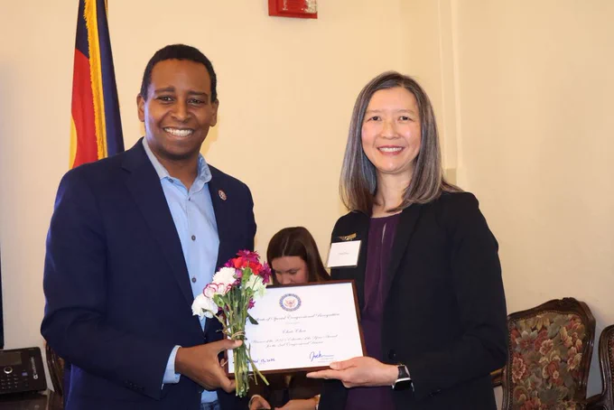 Image of State Rep Neguse holding a certificate with Teacher Chris Chou