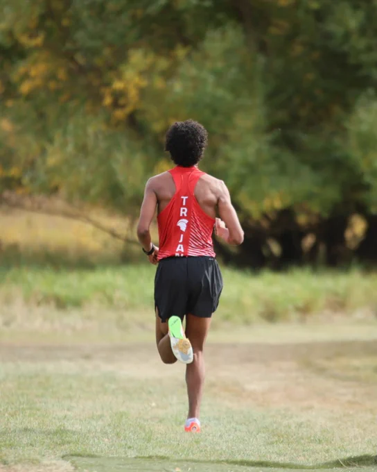 Cross-country runner Nathan Woyessa seen running on grass. 