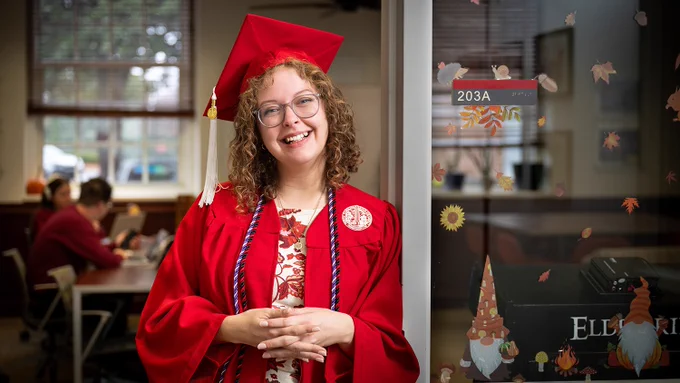 Alysha Jarvis smiles at the camera in her graduation regalia.