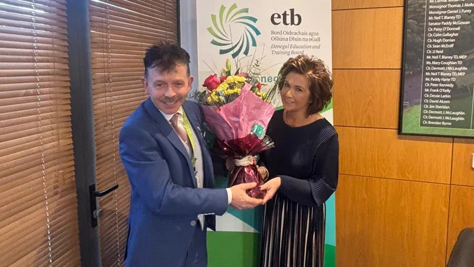 Person presenting flowers to another person. 