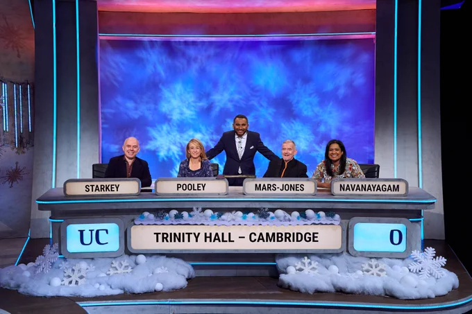 Dan Starkey, Dr Emma Pooley, Adam Mars-Jones and Datshiane Navanayagam sitting on the set of University Challenge. Standing behind them is University Challenge presenter and Cambridge alumnus Amol Rajan.
