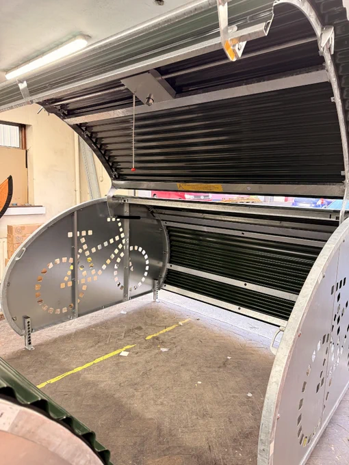 A completed BikeBunker is photographed with its door open inside a workshop.