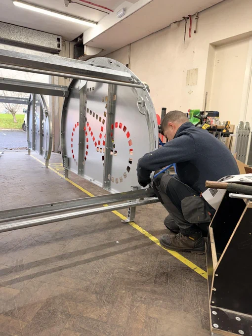 	A Bleeper technician is photographed assembling a BikeBunker inside a workshop.