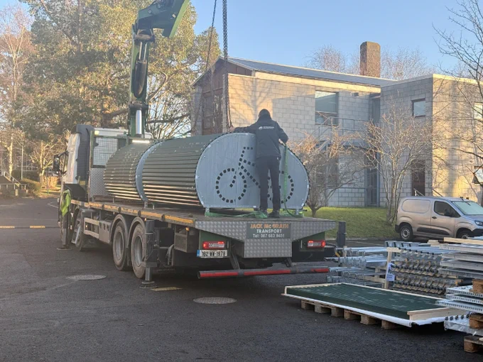 A flatbed truck is shown being loaded with two completed BikeBunkers.