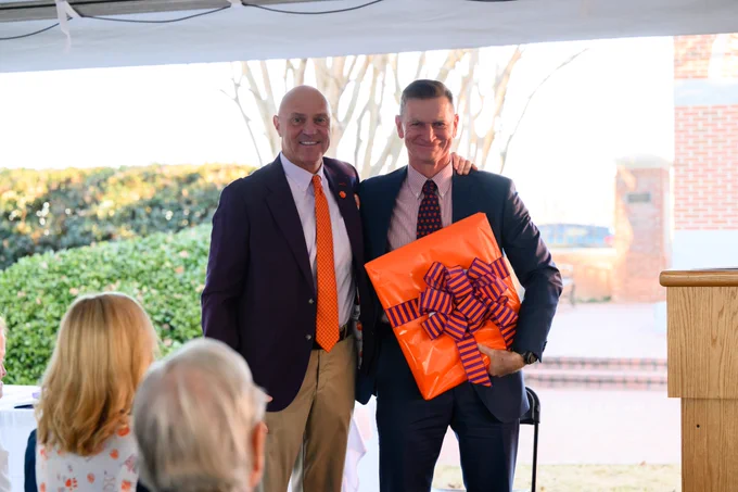 President Clements and Joe Ryan posing for a photo together holding a gift.