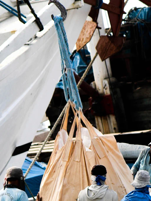 Photograph of a group of people standing on a dock next to a boat in Jakarta. By Pradamas Gifarry under a free Unsplash license: https://bit.ly/49JxOvU