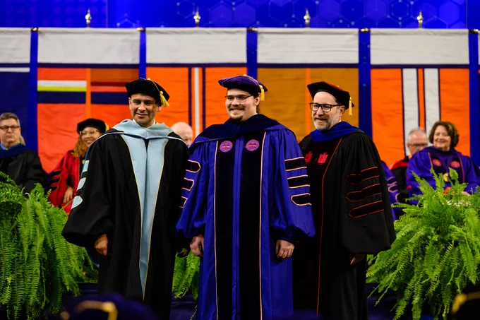 Three people posing for a photo at graduation.