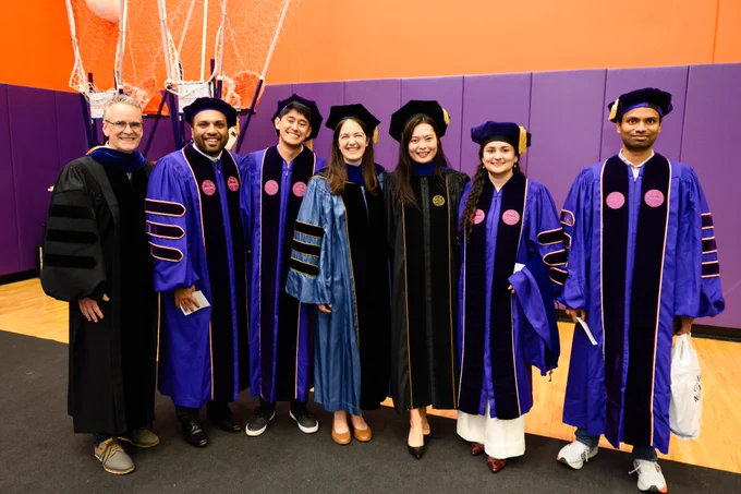 Seven people posing for a photo at graduation.