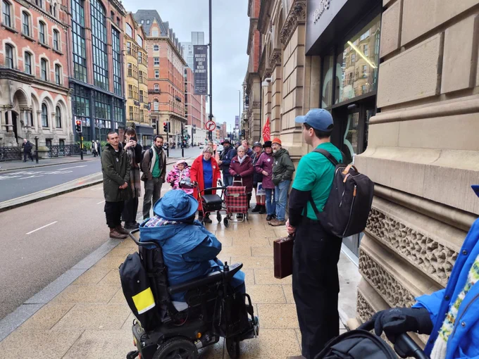 Me in my wheelchair addressing the crowd with a megaphone on the pavement outside Mayor’s office in Leeds
