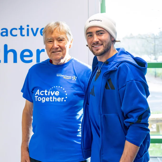 Leeds United player Jack Harrison stands alongside David, an Active Together member. They are both smiling at the camera.