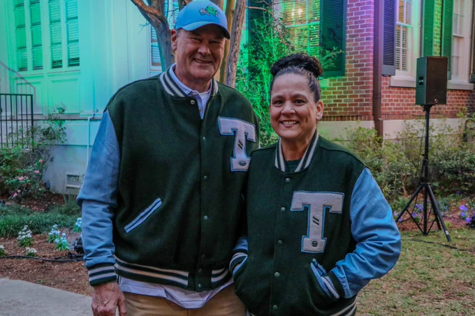 A Tulanian family smiling and supporting Tulane Football. 