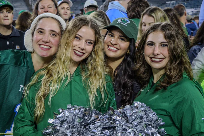 Tulanians smiling and supporting Tulane Football. 