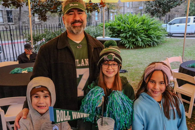 A Tulanian family smiling and supporting Tulane Football. 