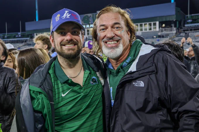 Tulanians smiling and supporting Tulane Football. 