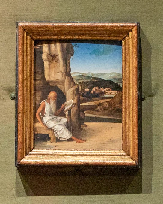 Saint Jerome Reading in a Landscape by Giovanni Bellini in a subtly gilded frame