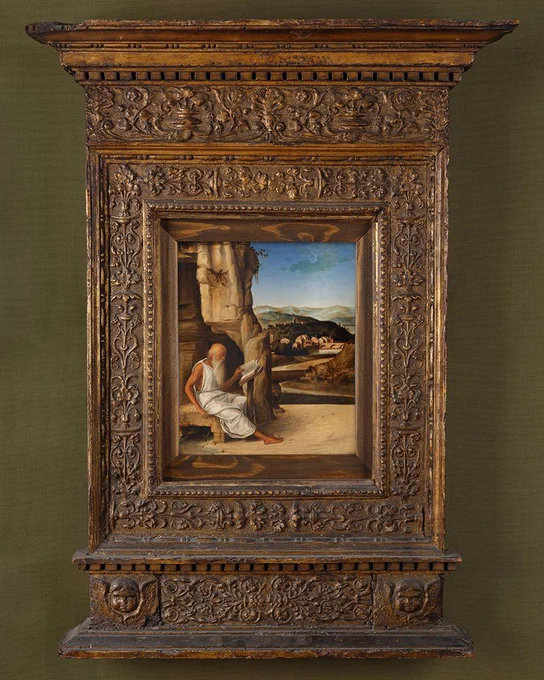 Saint Jerome Reading in a Landscape by Giovanni Bellini in a large, ornate frame