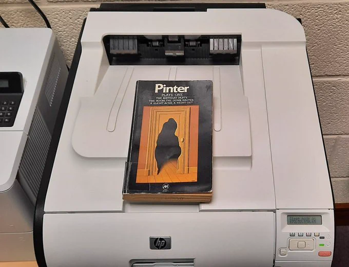 A book by Harold Pinter sitting on a printer
