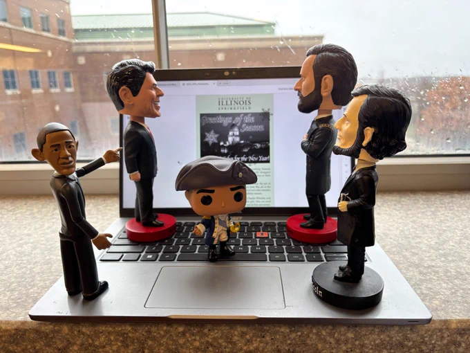 Bobblehead dolls of Barack Obama, Ronald Reagan, George Washington, Ulysses S. Grant and Abraham Lincoln "read" the PAR Alumni Newsletter on a laptop screen.